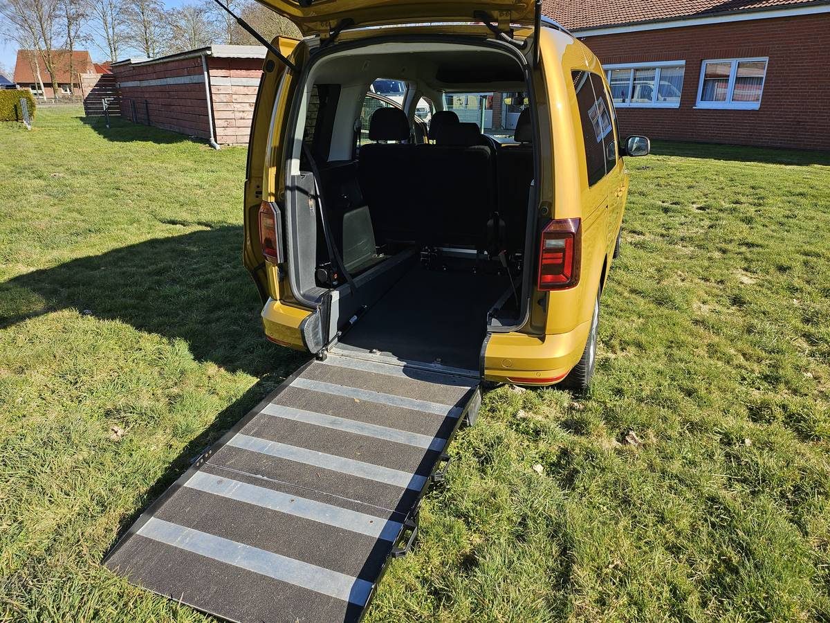 Gelber VW Caddy von Taxi Freese mit ausgeklappter Rollstuhlrampe