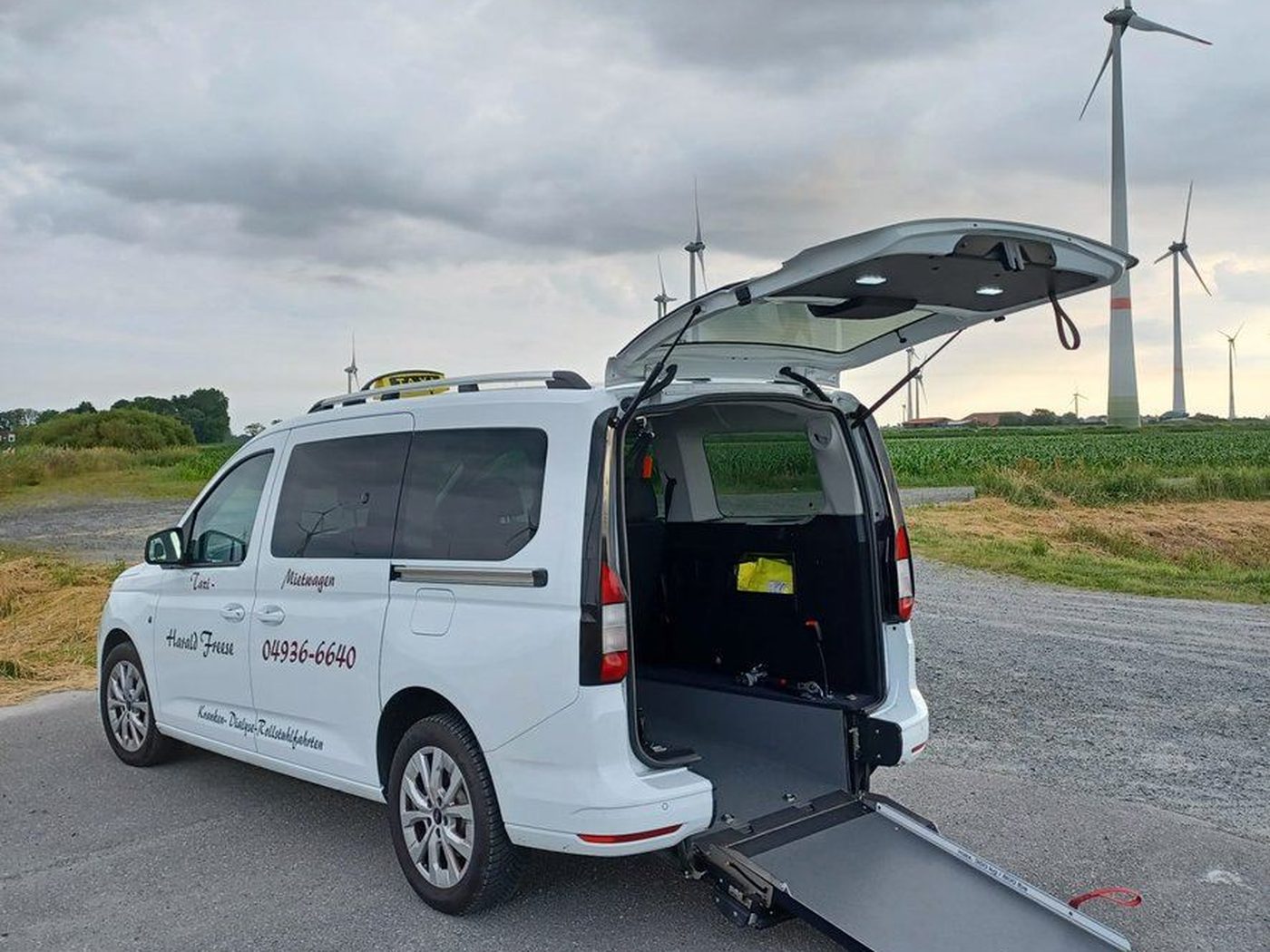 Fahrzeug von Taxi Freese mit ausgeklappter Rollstuhlrampe am Heck