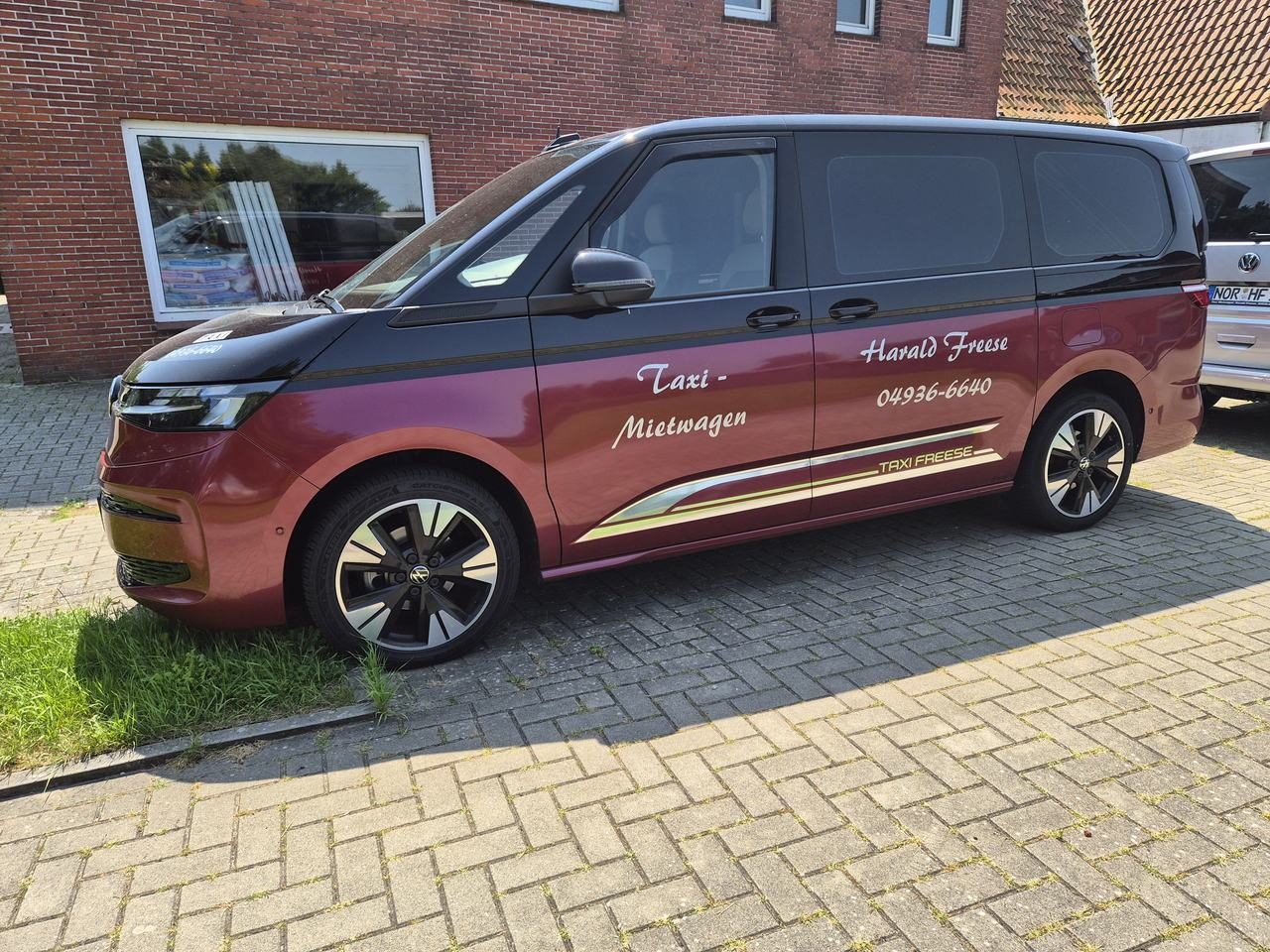 Roter VW Multivan von Taxi und Mietwagen Freese
