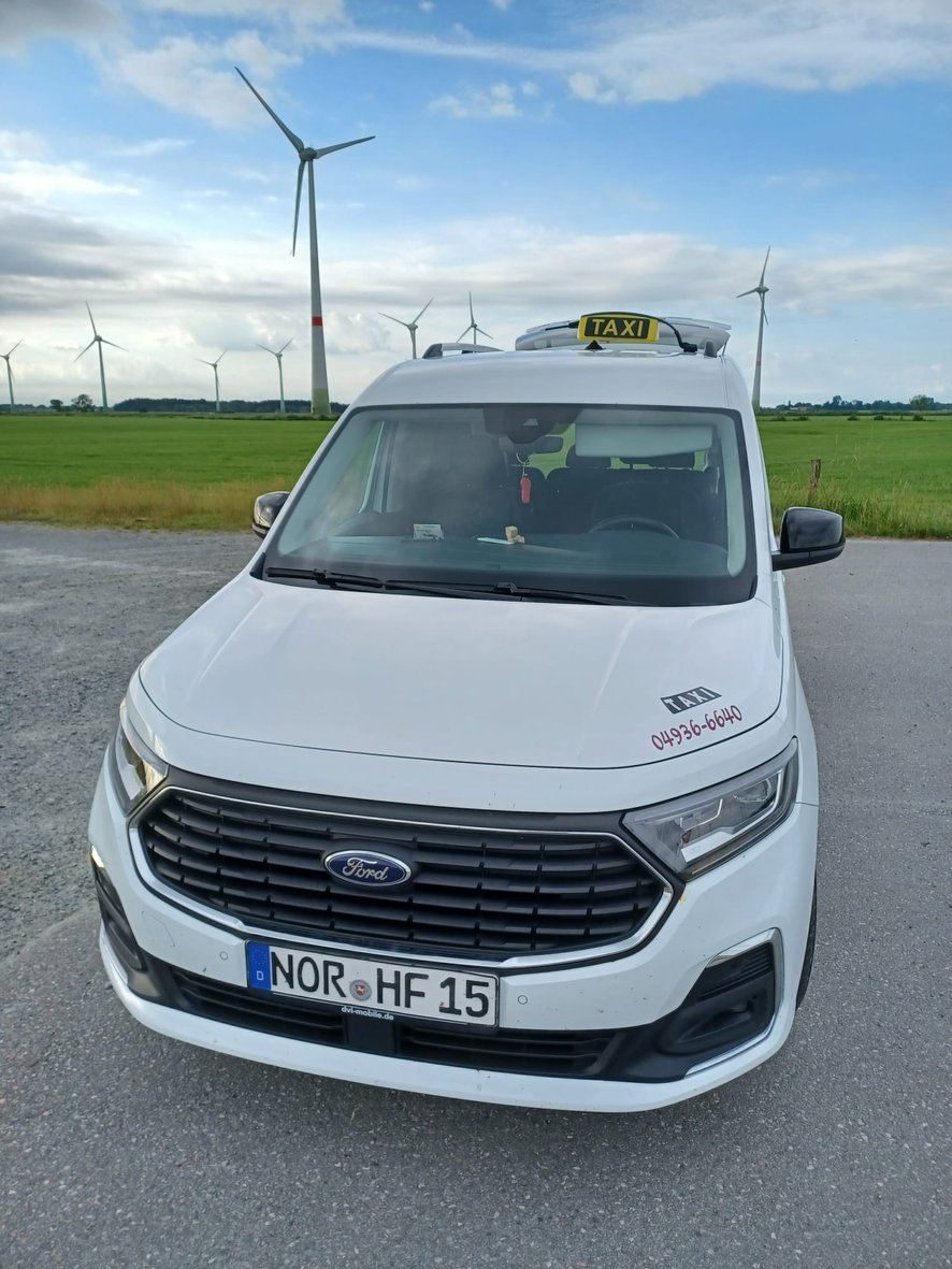 Weißer Ford Tourneo Connect Taxi von Taxi Freese vor Windrädern