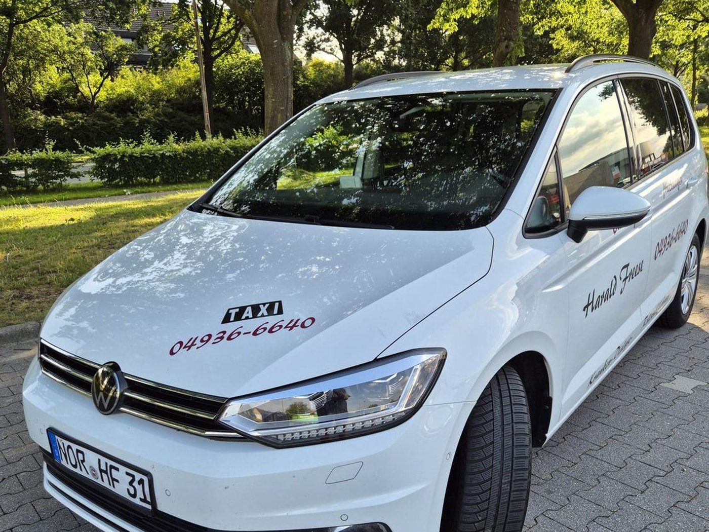 Weißer VW Touran von Taxi Freese mit Taxi-Schild – Kranken-, Dialyse- und Schülerfahrten